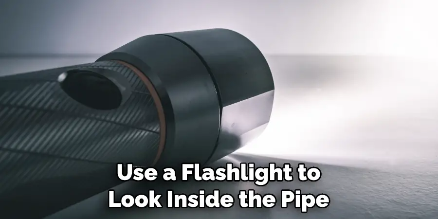 Use a Flashlight to Look Inside the Pipe