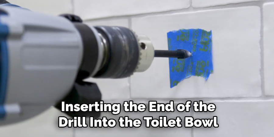 Inserting the End of the
Drill Into the Toilet Bowl