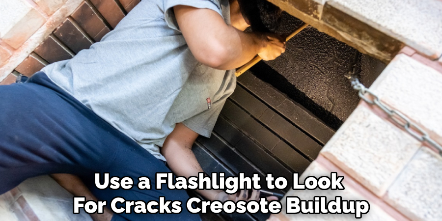 Use a Flashlight to Look 
For Cracks Creosote Buildup