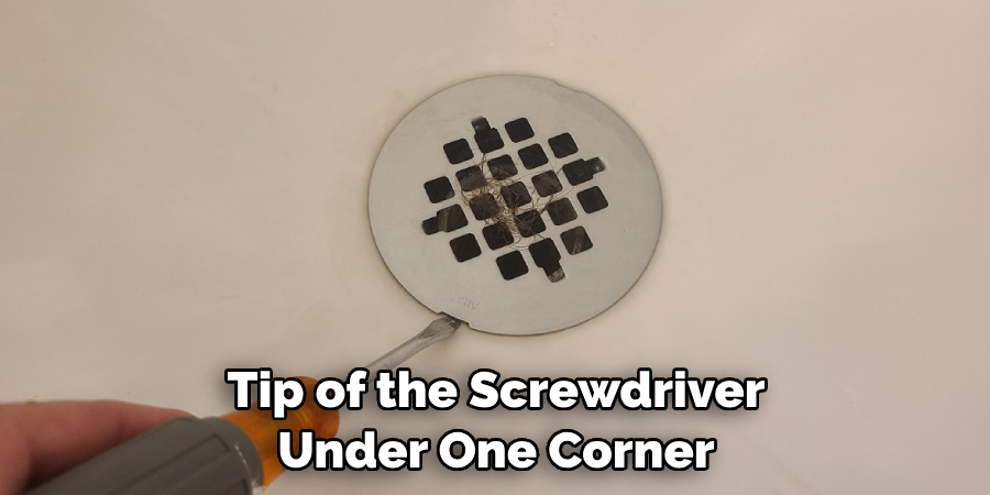 Tip of the Screwdriver Under One Corner